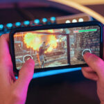 Hands of gamer playing mobile video games on his smartphone